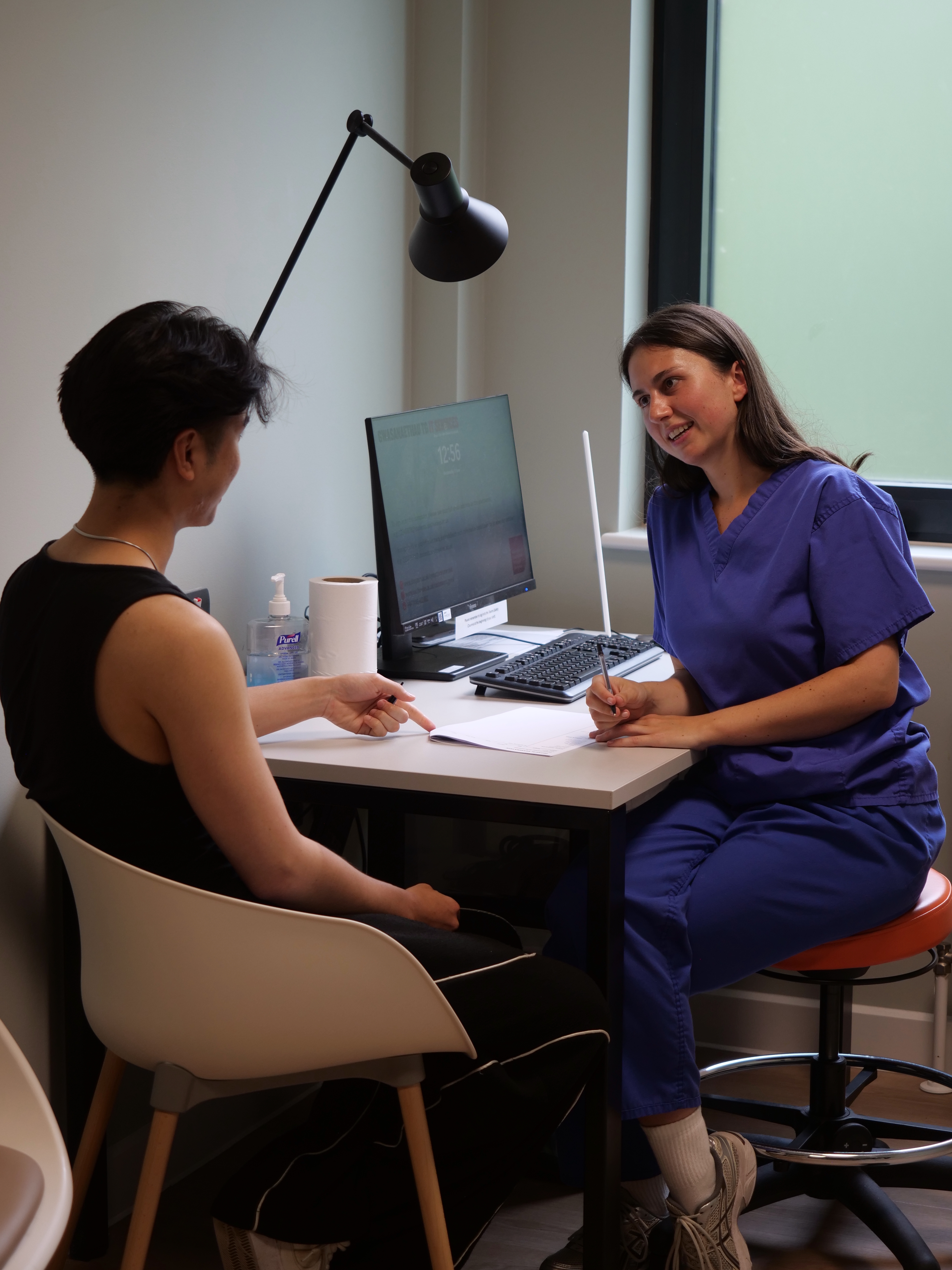 Chiropractor consulting with a patient at the desk
